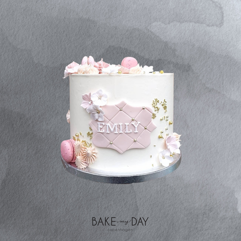 Kage med glat creme, macarons og blomster