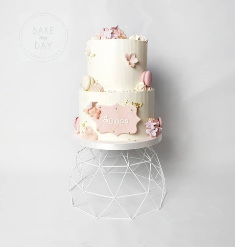 Kage med glat creme, macarons og blomster