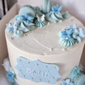 Kage med glat creme, macarons og blomster