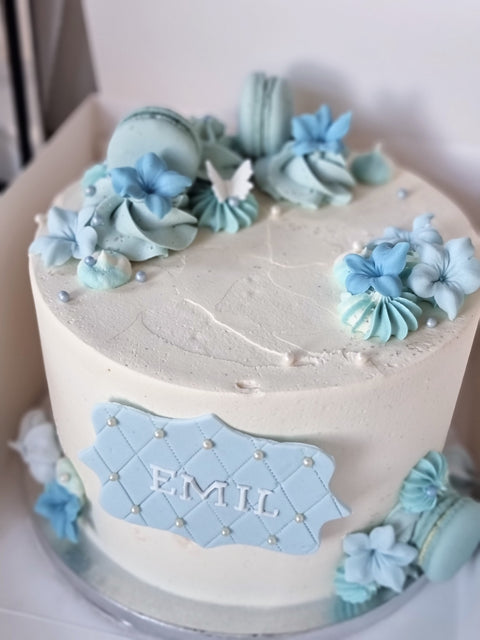 Kage med glat creme, macarons og blomster