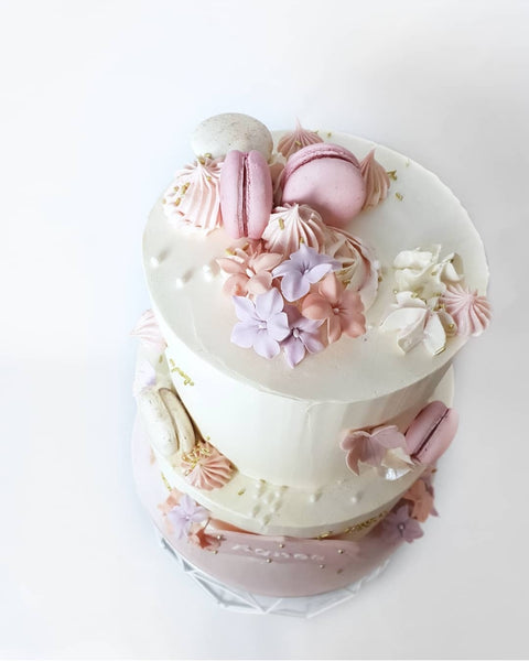 Kage med glat creme, macarons og blomster